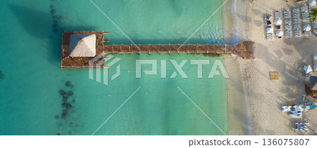 Top view of a small hut on a wooden pier on Bayahibe beach with turquoise water 136075807
