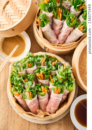 Steamed vegetables wrapped around pork loin in a steamer 136075949