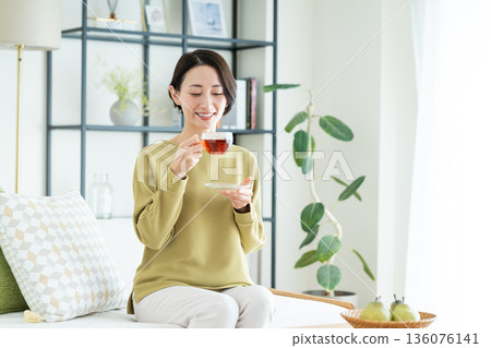 中年婦女在客廳喝茶 中年婦女在客廳喝茶 136076141