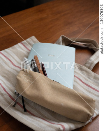 Pencil case, notebook and bag on the desk 136076508