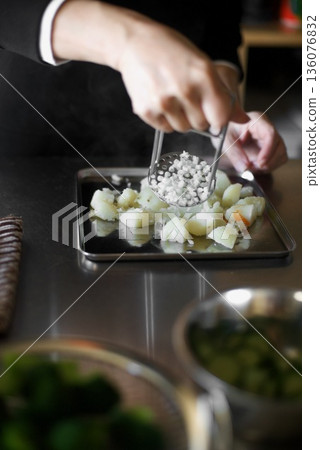 Mashing boiled potatoes with a masher Mashing boiled potatoes with a masher 136076832