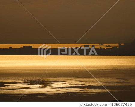 Morning light creates cityscape shadows, Sunrise casting warm hues over city edge outlines visually striking 136077459