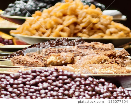 Artisan confections on rustic tables, Colorful market setup featuring assortment of confections and nuts 136077504