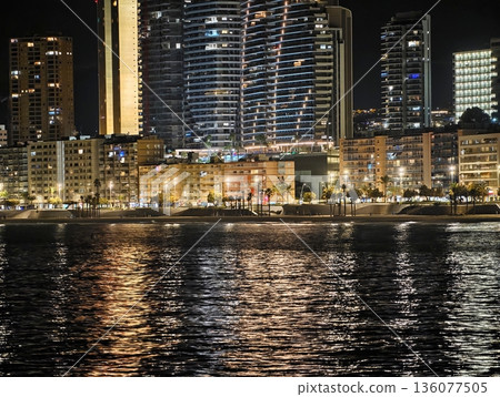 Reflective water enhances cityscape, Tranquil riverbank reflecting vibrant city skyline at night Reflective water enhances cityscape, Tranquil riverbank reflecting vibrant city skyline at night 136077505