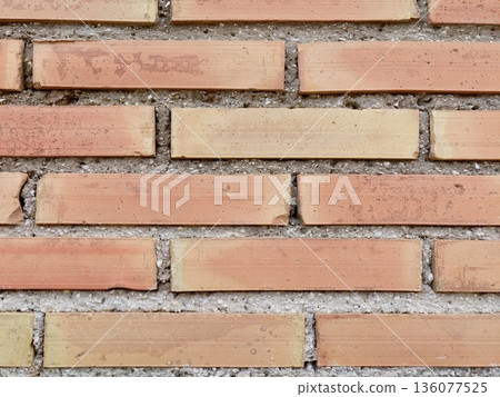 Detailed view of aged brick wall displaying rough surface and subtle shadows suitable for design projects 136077525