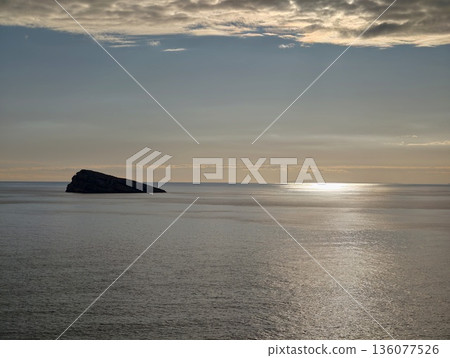 Peaceful morning reflection, Quiet ocean landscape at dawn featuring smooth waves and warm sunlit hues 136077526