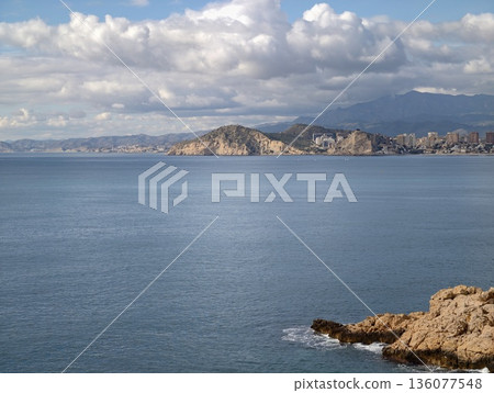 Serene island with calm waters, Gentle horizon and peaceful shoreline create relaxing scenery Serene island with calm waters, Gentle horizon and peaceful shoreline create relaxing scenery 136077548