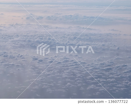 Aerial view sunrise clouds over sea with warm pastel glow and distant horizon travel blogger perspective 136077722