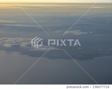 Peaceful turquoise shoreline from above, Elevated image showcasing serene azure waters and drifting clouds Peaceful turquoise shoreline from above, Elevated image showcasing serene azure waters and drifting clouds 136077728