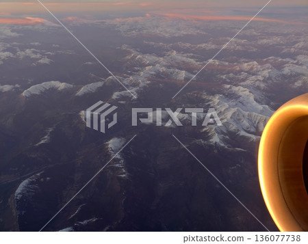 Sunset illumination on aircraft parts, Sunset reflecting off aircraft engine above mountain range 136077738