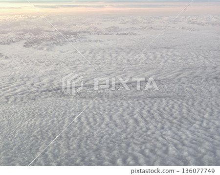 Skyline streak cutting through fluffy clouds, Line of vapor piercing gentle cloud cover beneath pastel hues Skyline streak cutting through fluffy clouds, Line of vapor piercing gentle cloud cover beneath pastel hues 136077749