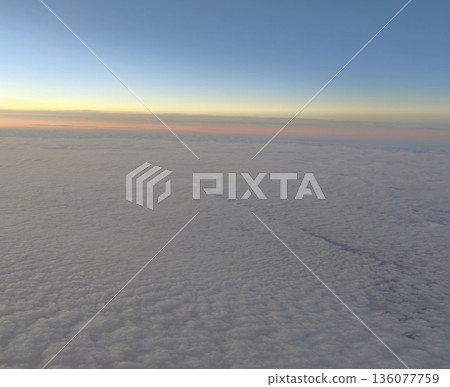 Expansive early morning cloud formation blending gentle pastel colors with calming horizon glow for relaxation Expansive early morning cloud formation blending gentle pastel colors with calming horizon glow for relaxation 136077759