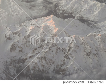 Sunrise peak with rugged terrain, Early morning summit scene with pink hues on rugged mountain features 136077768