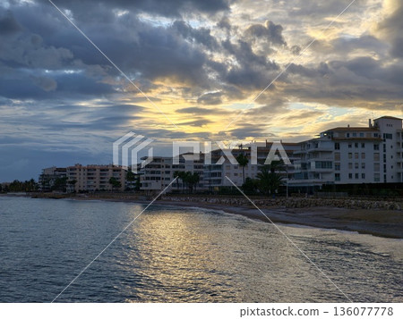 Quiet evening with peaceful waterfront view, Tranquil dusk over coastal walkway with soft glowing clouds Quiet evening with peaceful waterfront view, Tranquil dusk over coastal walkway with soft glowing clouds 136077778