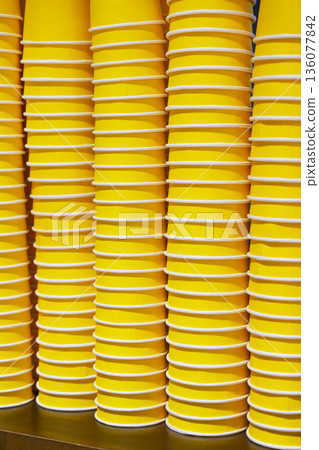 Large group of eco-friendly yellow paper coffee cups on a wooden cafe table Large group of eco-friendly yellow paper coffee cups on a wooden cafe table 136077842
