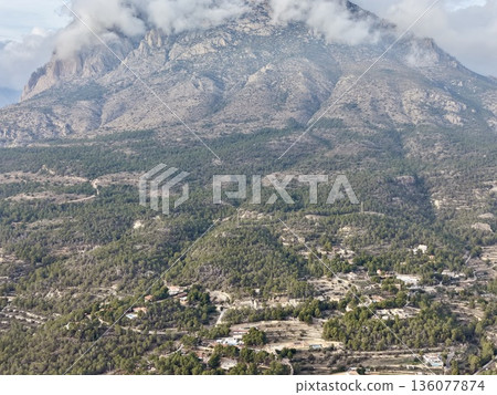 Village nestled among green terraces, Serene rural settlement set amid lush green slopes and olive groves Village nestled among green terraces, Serene rural settlement set amid lush green slopes and olive groves 136077874