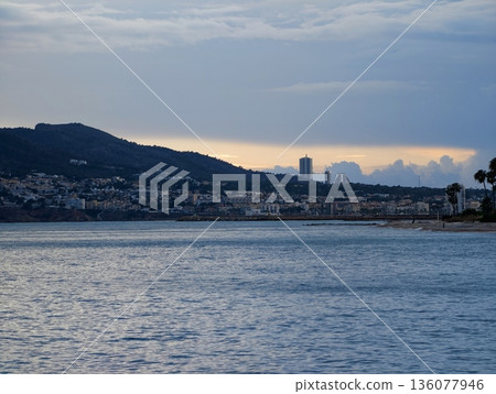 Serene coastal view during dusk hours, Peaceful evening by water with gentle waves and palm shadows Serene coastal view during dusk hours, Peaceful evening by water with gentle waves and palm shadows 136077946