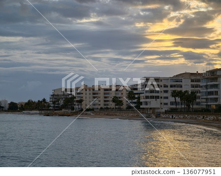 Calm bay with luminous buildings, Evening at waterfront showing peaceful bay and illuminated structures 136077951