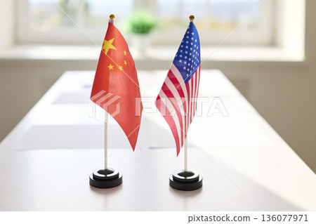 Miniature China and USA flags on conference table, symbolizing negotiation Miniature China and USA flags on conference table, symbolizing negotiation 136077971