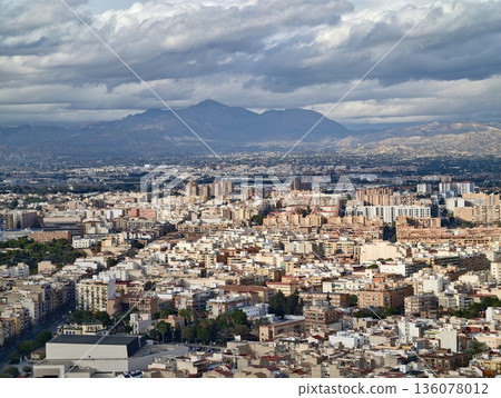 Urban view with mountain backdrop, Resilient cityscape featuring layered ridgelines and stormy clouds Urban view with mountain backdrop, Resilient cityscape featuring layered ridgelines and stormy clouds 136078012