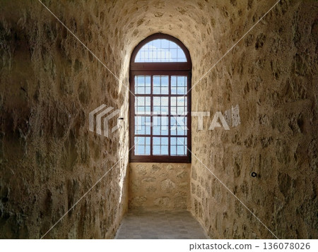 Warm glow through old stone corridor, Sunlit arched opening enhances historic stone corridor ambiance Warm glow through old stone corridor, Sunlit arched opening enhances historic stone corridor ambiance 136078026