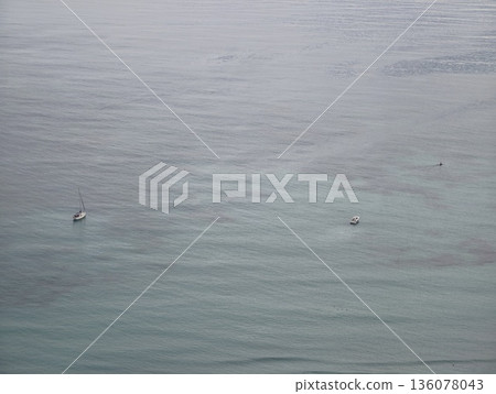 Solitary vessels on tranquil waters, Peaceful scene featuring floating boats and calm waves 136078043