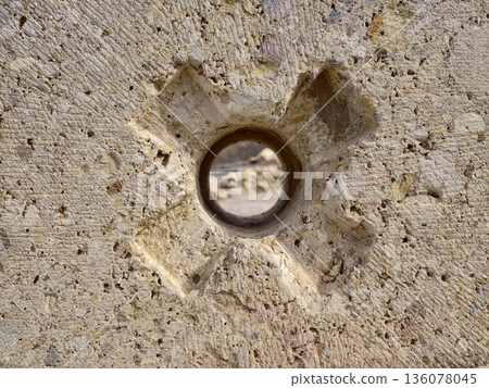 Corroded iron embedded in stone surface, Closeup of metal ring set into stone with cut marks Corroded iron embedded in stone surface, Closeup of metal ring set into stone with cut marks 136078045