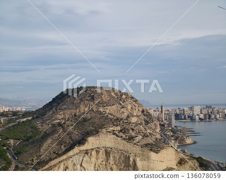 Rugged mountain rise presenting sweeping vistas of shoreline and metropolitan skyline below 136078059