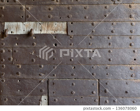 Vintage metal gate, Weathered iron door with repairs, Old rusted metal door showing signs of repair 136078060