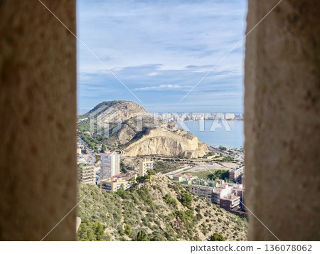 Coastal cliff with harbor background, Rugged cliffs surround calm sea and scattered coastal structures 136078062