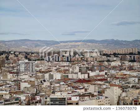 Urban area with varied rooftops, Dense city neighborhood featuring muted tones and distant hills 136078070