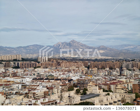Panoramic scene displaying prominent mountain peak above dense city grid with clear atmosphere Panoramic scene displaying prominent mountain peak above dense city grid with clear atmosphere 136078071
