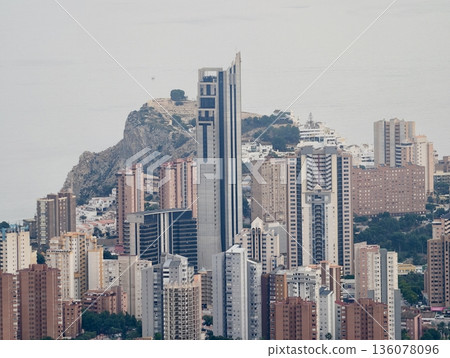 City skyline scene, Highrise building with rugged mountain background and surrounding structures City skyline scene, Highrise building with rugged mountain background and surrounding structures 136078096