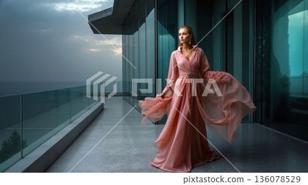 A woman in a pink dress standing on a balcony 136078529