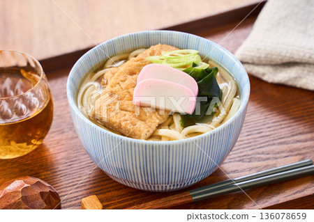 Kitsune udon noodles served with large fried tofu and kamaboko fish cake Kitsune udon noodles served with large fried tofu and kamaboko fish cake 136078659
