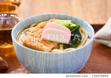 Kitsune udon noodles served with large fried tofu and kamaboko fish cake Kitsune udon noodles served with large fried tofu and kamaboko fish cake 136078664
