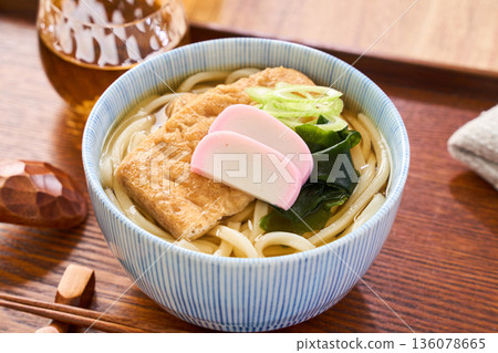 Kitsune udon noodles served with large fried tofu and kamaboko fish cake Kitsune udon noodles served with large fried tofu and kamaboko fish cake 136078665