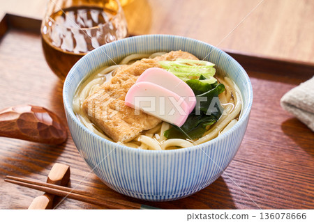 Kitsune udon noodles served with large fried tofu and kamaboko fish cake Kitsune udon noodles served with large fried tofu and kamaboko fish cake 136078666