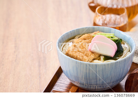 Kitsune udon noodles served with large fried tofu and kamaboko fish cake Kitsune udon noodles served with large fried tofu and kamaboko fish cake 136078669