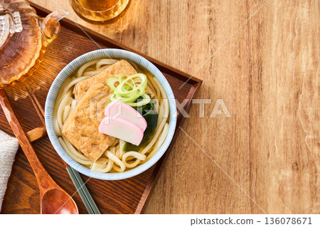 Kitsune udon noodles served with large fried tofu and kamaboko fish cake Kitsune udon noodles served with large fried tofu and kamaboko fish cake 136078671