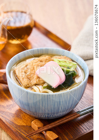 Kitsune udon noodles served with large fried tofu and kamaboko fish cake Kitsune udon noodles served with large fried tofu and kamaboko fish cake 136078674