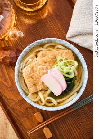 Kitsune udon noodles served with large fried tofu and kamaboko fish cake Kitsune udon noodles served with large fried tofu and kamaboko fish cake 136078675