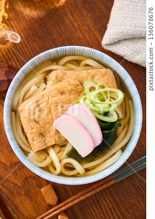 Kitsune udon noodles served with large fried tofu and kamaboko fish cake Kitsune udon noodles served with large fried tofu and kamaboko fish cake 136078676