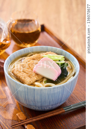 Kitsune udon noodles served with large fried tofu and kamaboko fish cake Kitsune udon noodles served with large fried tofu and kamaboko fish cake 136078677