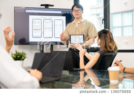Asian man holding tablet getting ask by coworker during mobile app presenting in office meeting room Asian man holding tablet getting ask by coworker during mobile app presenting in office meeting room 136078888