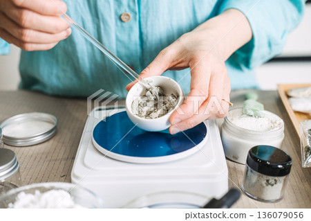 Hands use glass stirrer to mix powder in small ceramic bowl on digital scale. Postbiotic masks, barrier repair, rice ferment skincare. Hands use glass stirrer to mix powder in small ceramic bowl on digital scale. Postbiotic masks, barrier repair, rice ferment skincare. 136079056