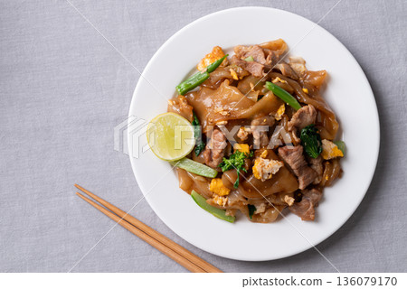 Top view of Thai food (Pad See Ew), Stir-fried rice noodles with soy sauce, pork, egg, and kale Top view of Thai food (Pad See Ew), Stir-fried rice noodles with soy sauce, pork, egg, and kale 136079170