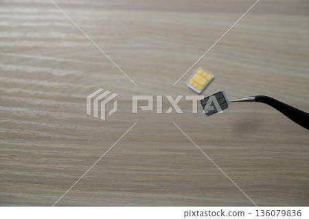 用鑷子夾起Nano SIM卡 136079836