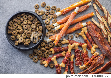 Dog food. Snack sticks for dogs and dry kibble food on gray table. Top view. 136080127
