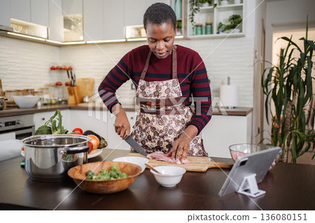 Woman preparing healthy dinner with meat and vegetables at home kitchen 136080151